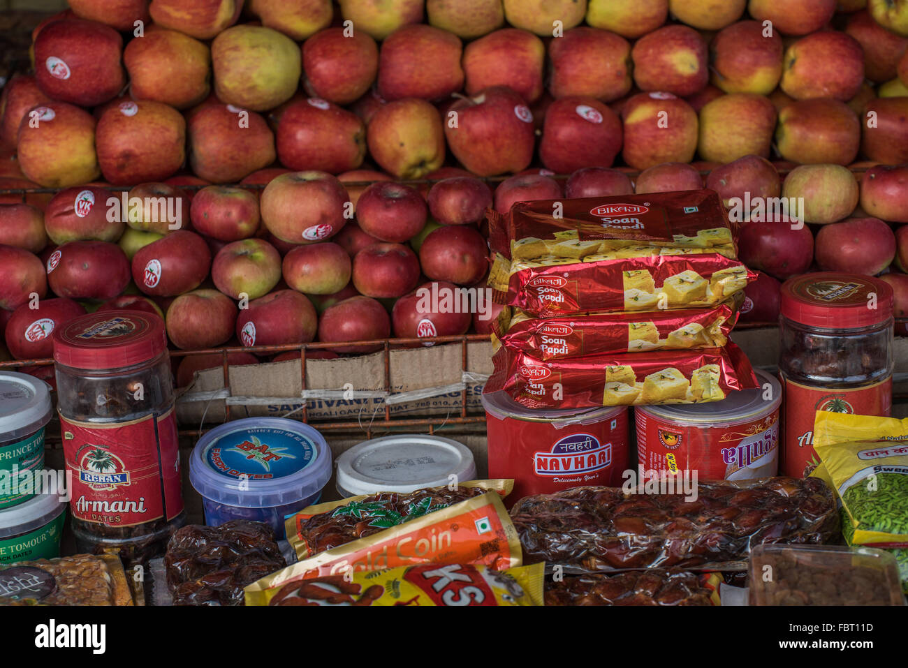 Vibrant fresh apples and packets of savory and sweet Indian snacks. Market at Majuli Island Ferry Port, Assam, India. Stock Photo