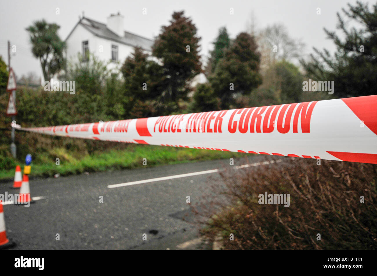 Police 'Inner Cordon' tape is stretched across a road at the scene of a murder investigation. Stock Photo