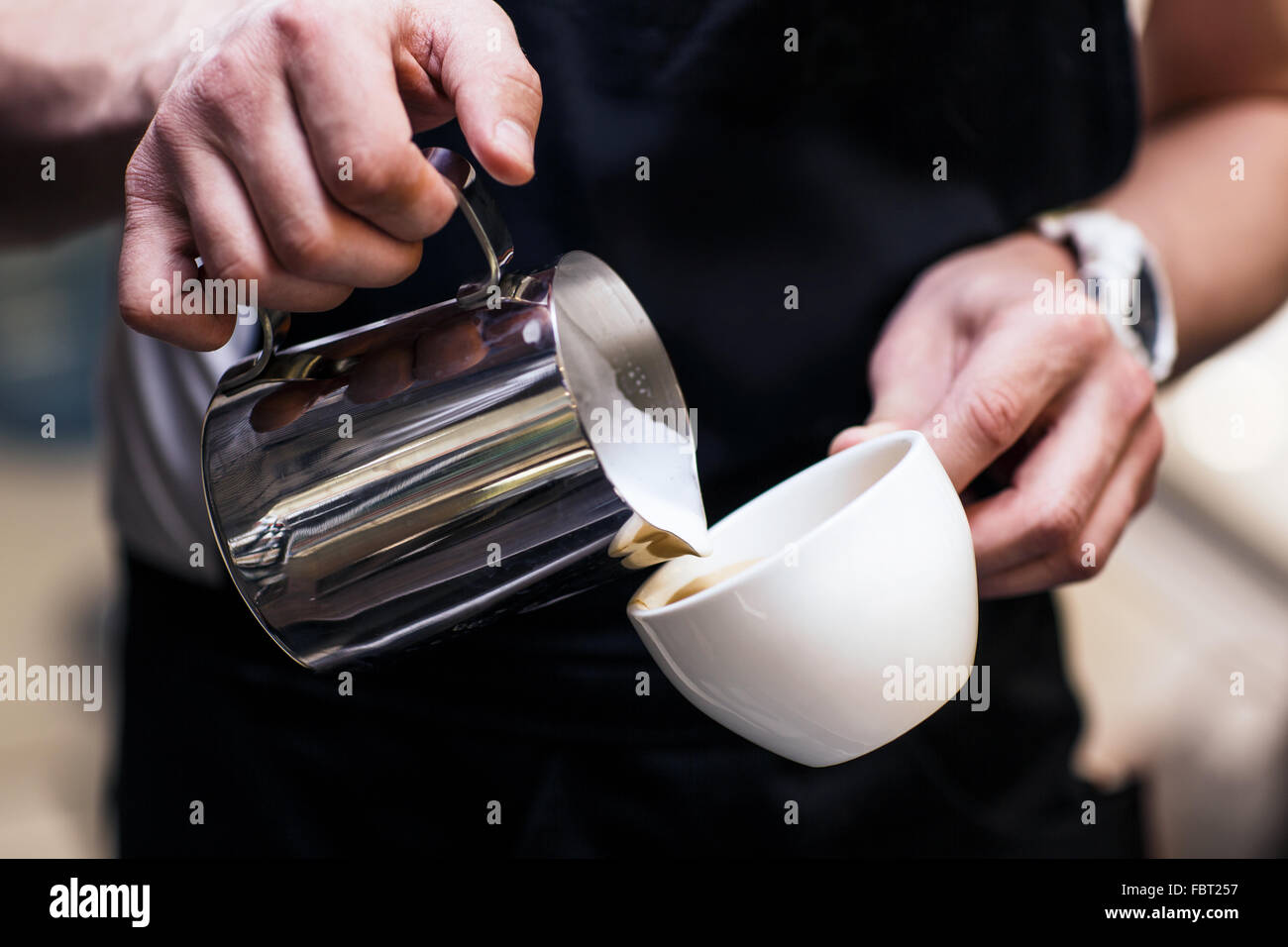 Barista making coffee pouring milk Stock Photo