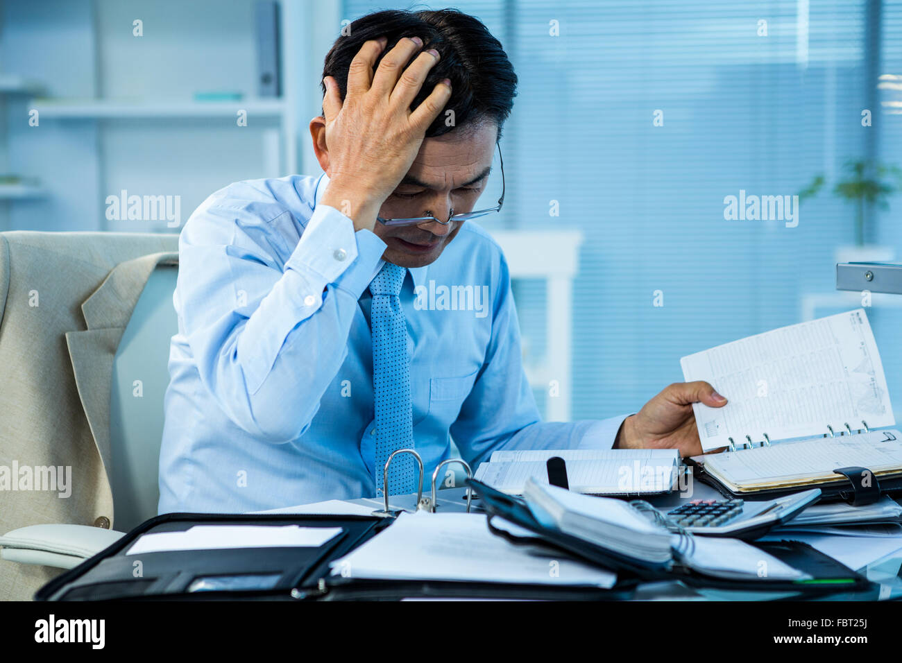 Stressed businessman with a big amount of work Stock Photo