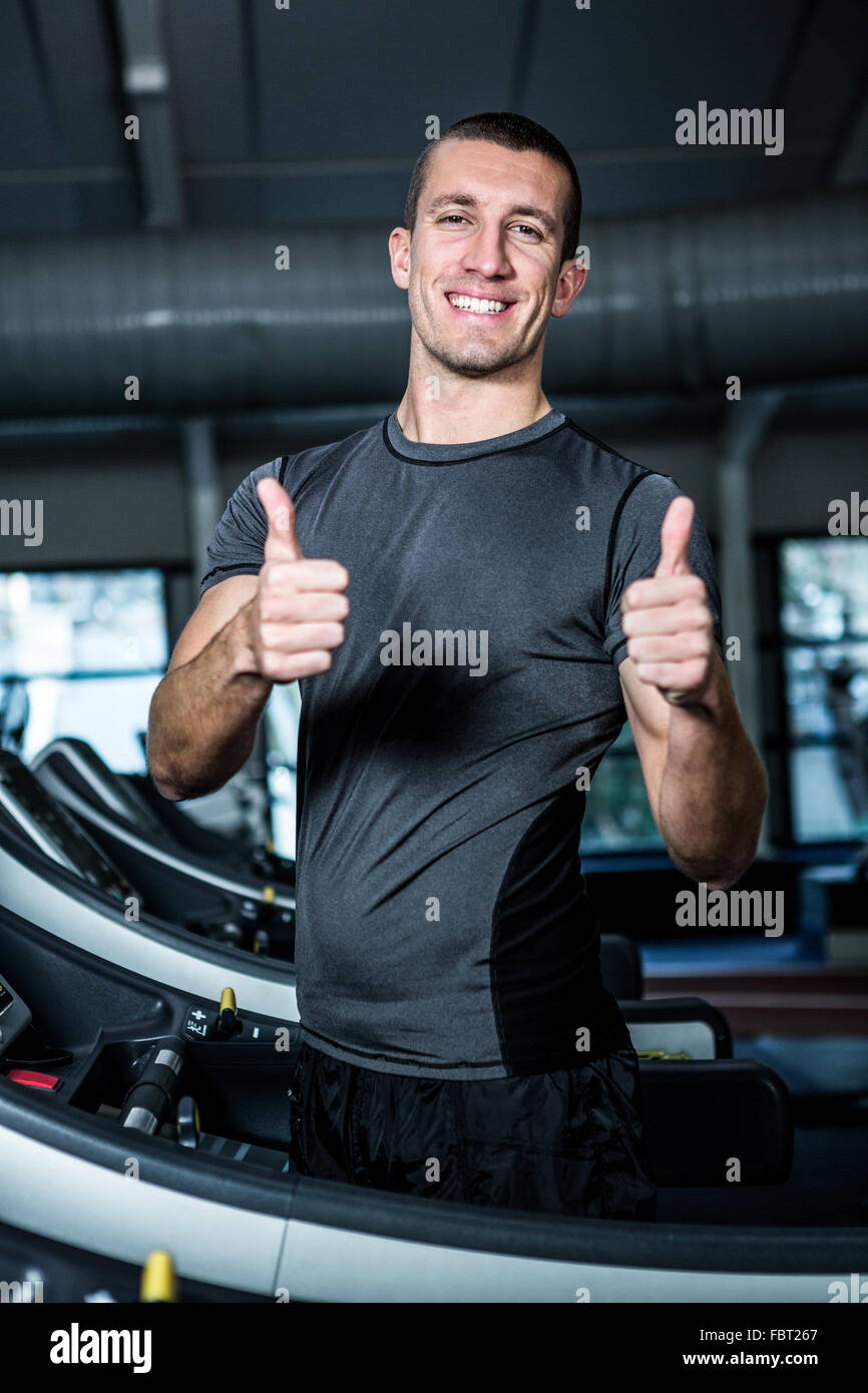 Muscular man on treadmill showing thumbs up Stock Photo - Alamy