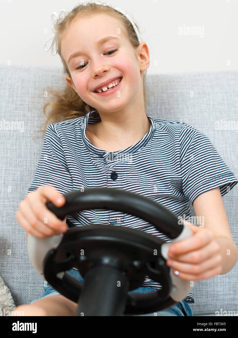 Little girl playing game with steering wheel Stock Photo Alamy