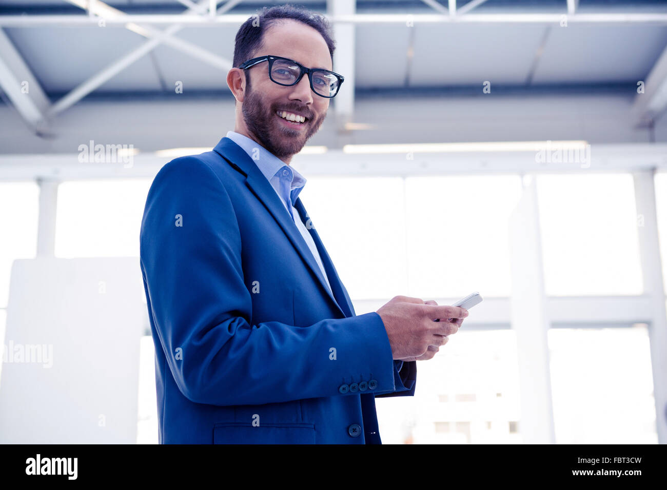 Portrait of happy businessman holding smartphone in office Stock Photo ...