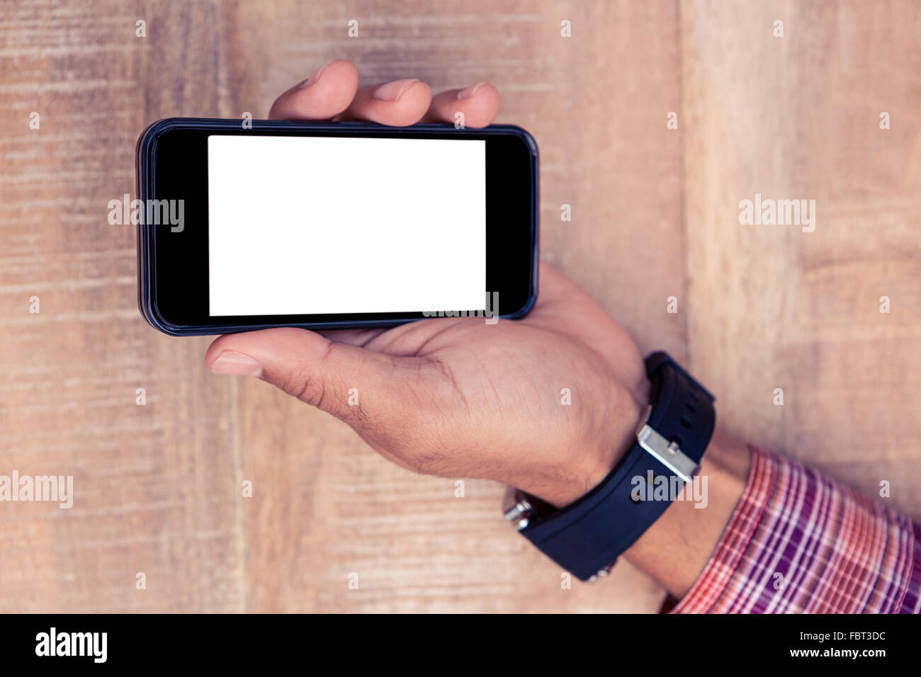Man holding smart phone on desk Stock Photo