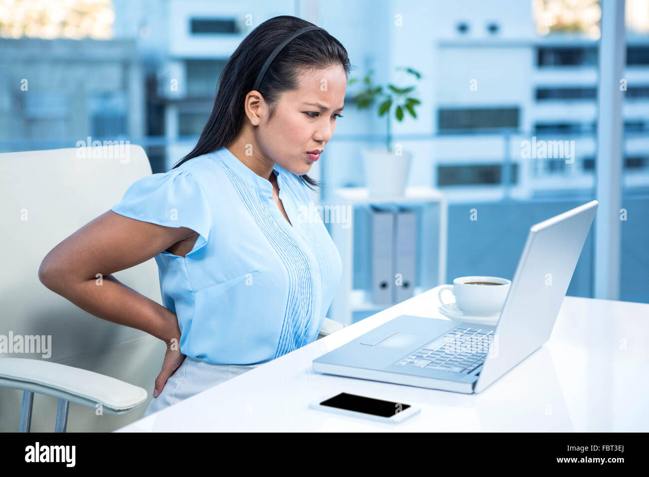 Sad businesswoman having back pain Stock Photo