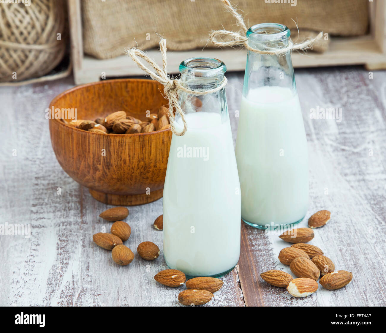 Almond milk in bottles with almond nuts on wooden background Stock Photo
