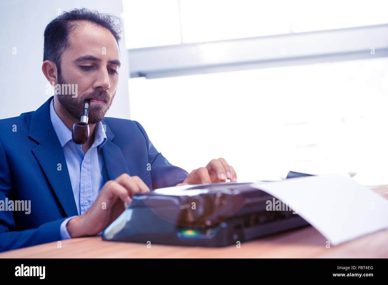Hipster businessman working on typewriter in office Stock Photo