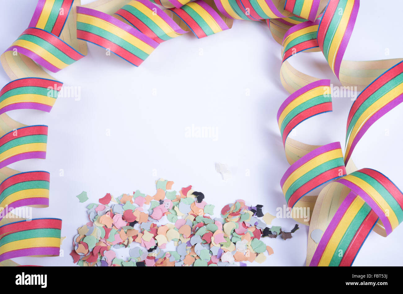 confetty and colorful streamers on white background Stock Photo - Alamy
