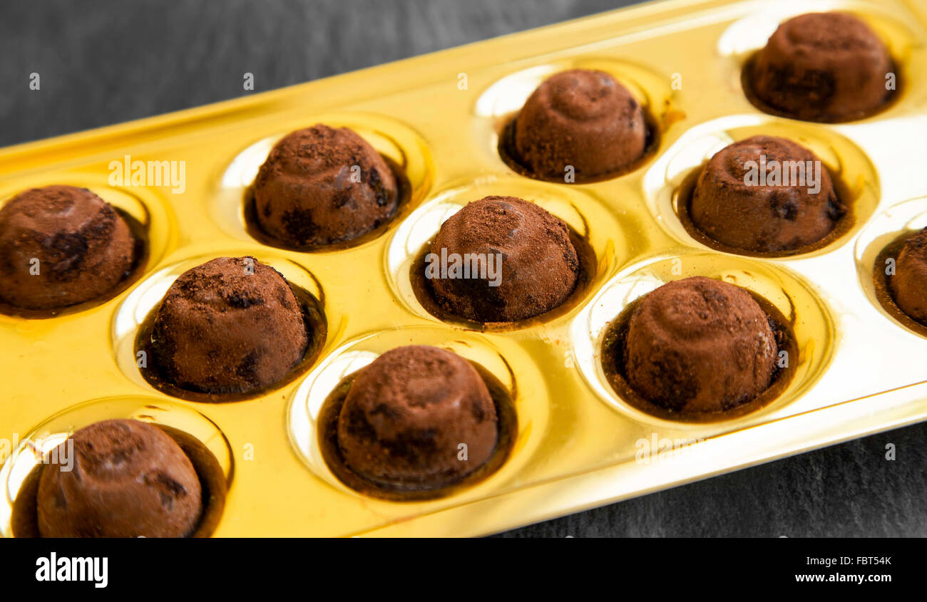 Chocolate pralines with cocoa powder in golden package Stock Photo