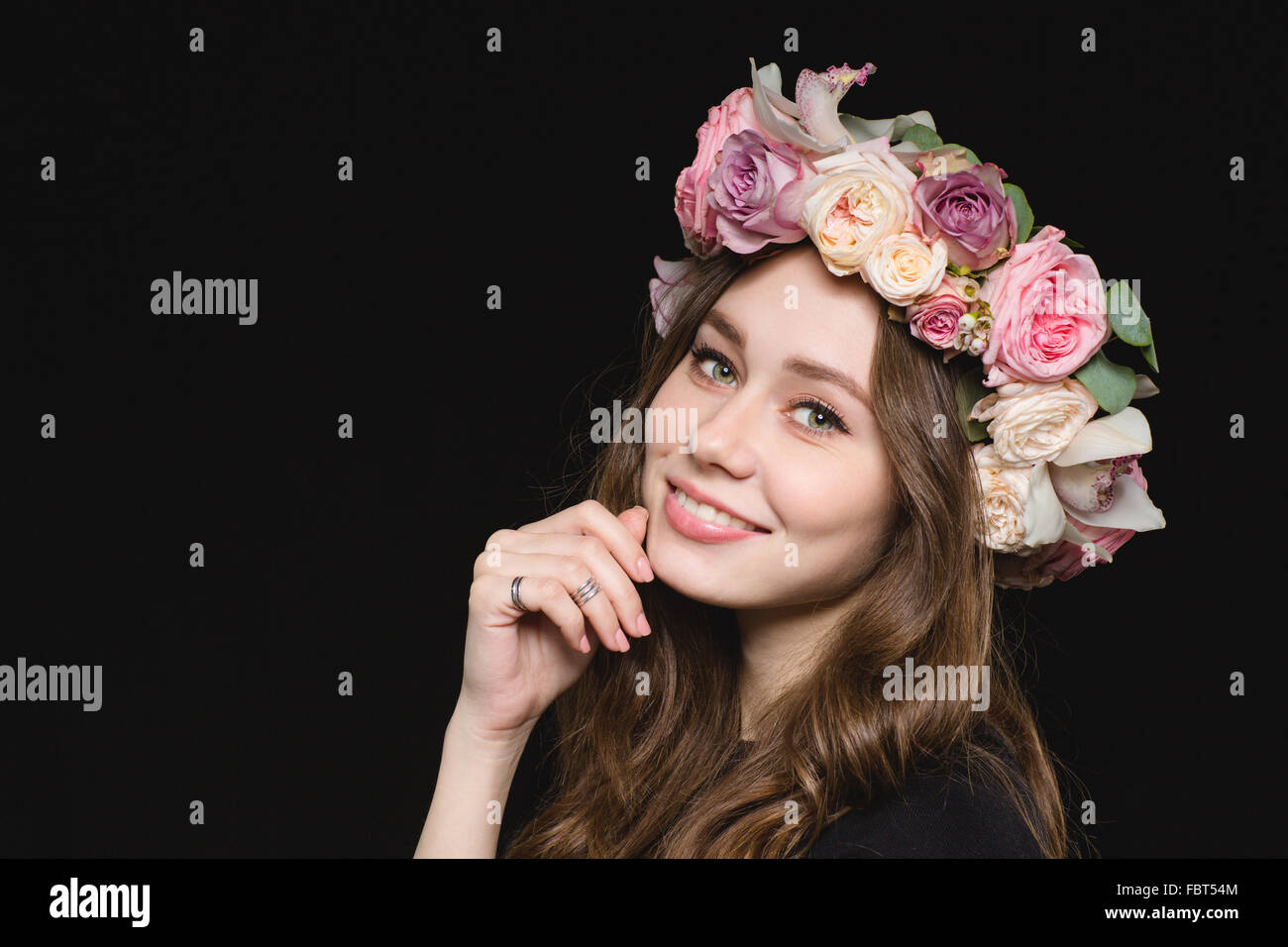 Portrait of beautiful happy young woman with long hair in flower wreath ...