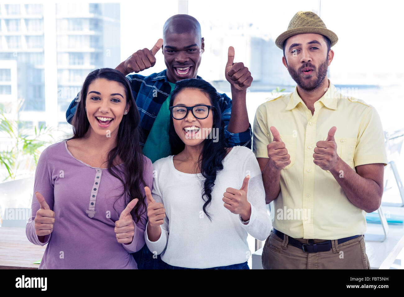 Portrait of creative business people with thumbs up Stock Photo - Alamy