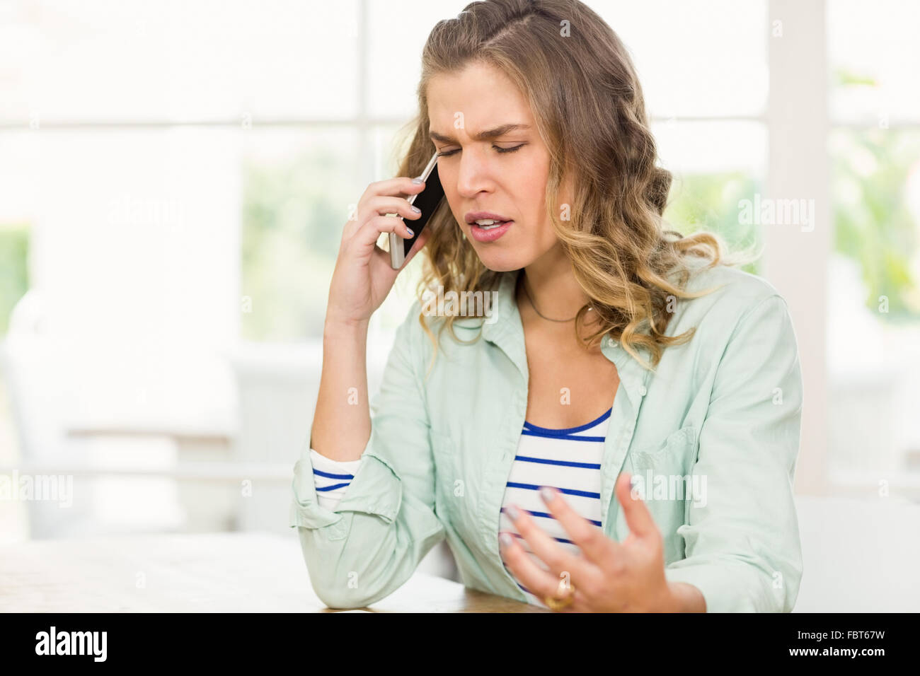 Frowning woman having phone call Stock Photo - Alamy