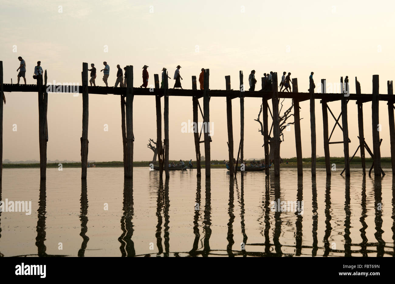 Silhouettes of people crossing the U Bein bridge in Amarapura near ...