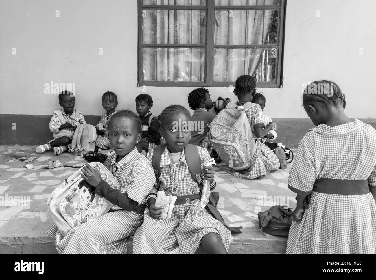 Lunch break for black infant children at a charity run school in the back streets of Kololi Gambia Stock Photo