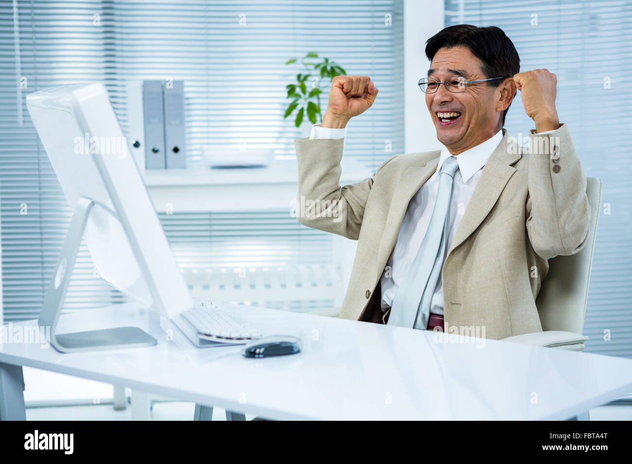 Excited businessman using pc hi-res stock photography and images - Alamy