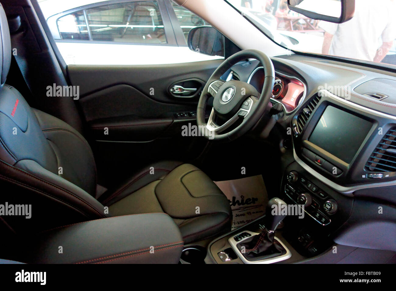 The front interior seats dash and steering wheel and navigation screen of a 2015 2016 Jeep Cherokee Trailhawk Trail Hawk vehicle Stock Photo