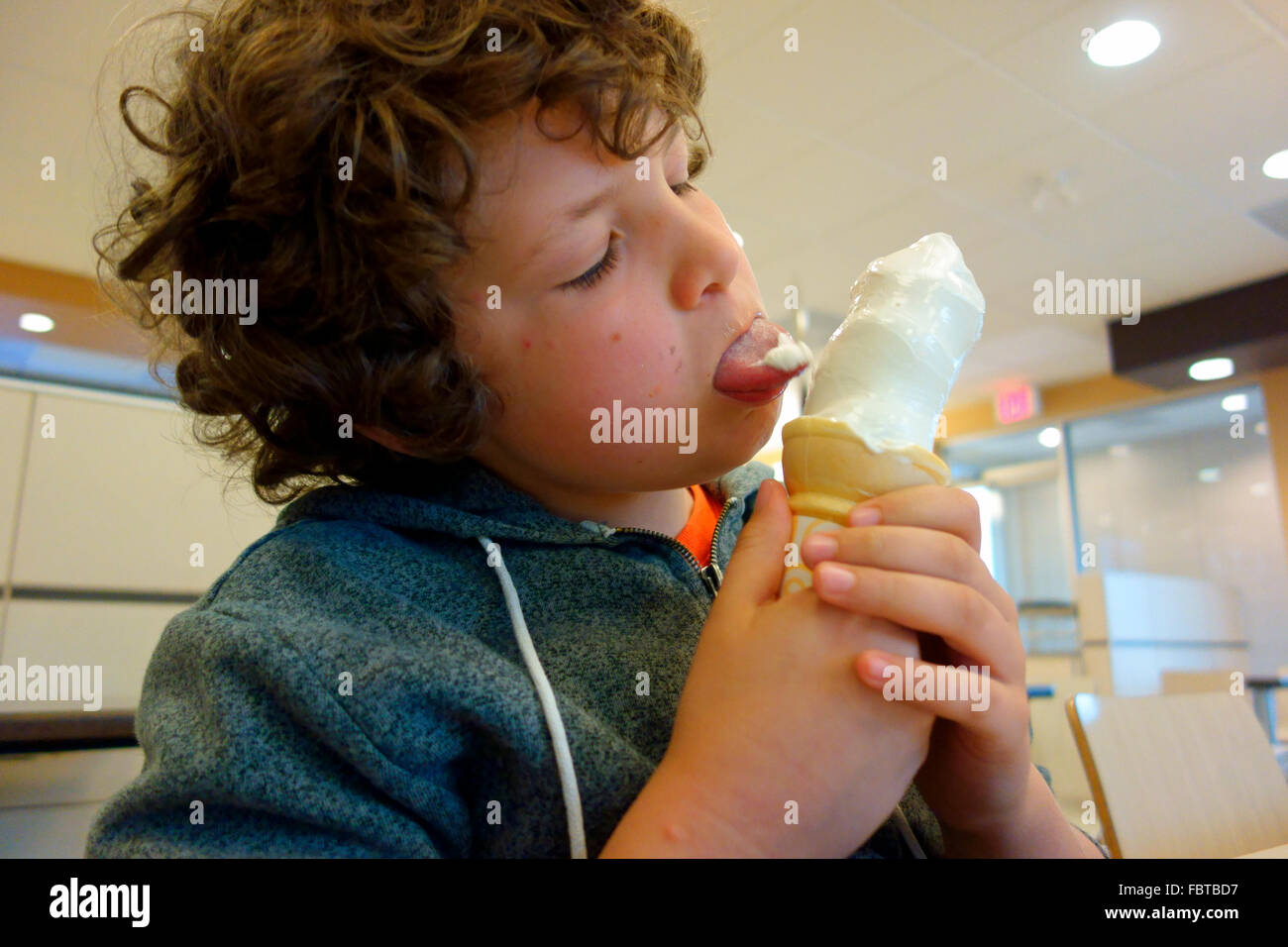 an 8 year old boy licking and eating an ice cream cone Stock Photo Alamy