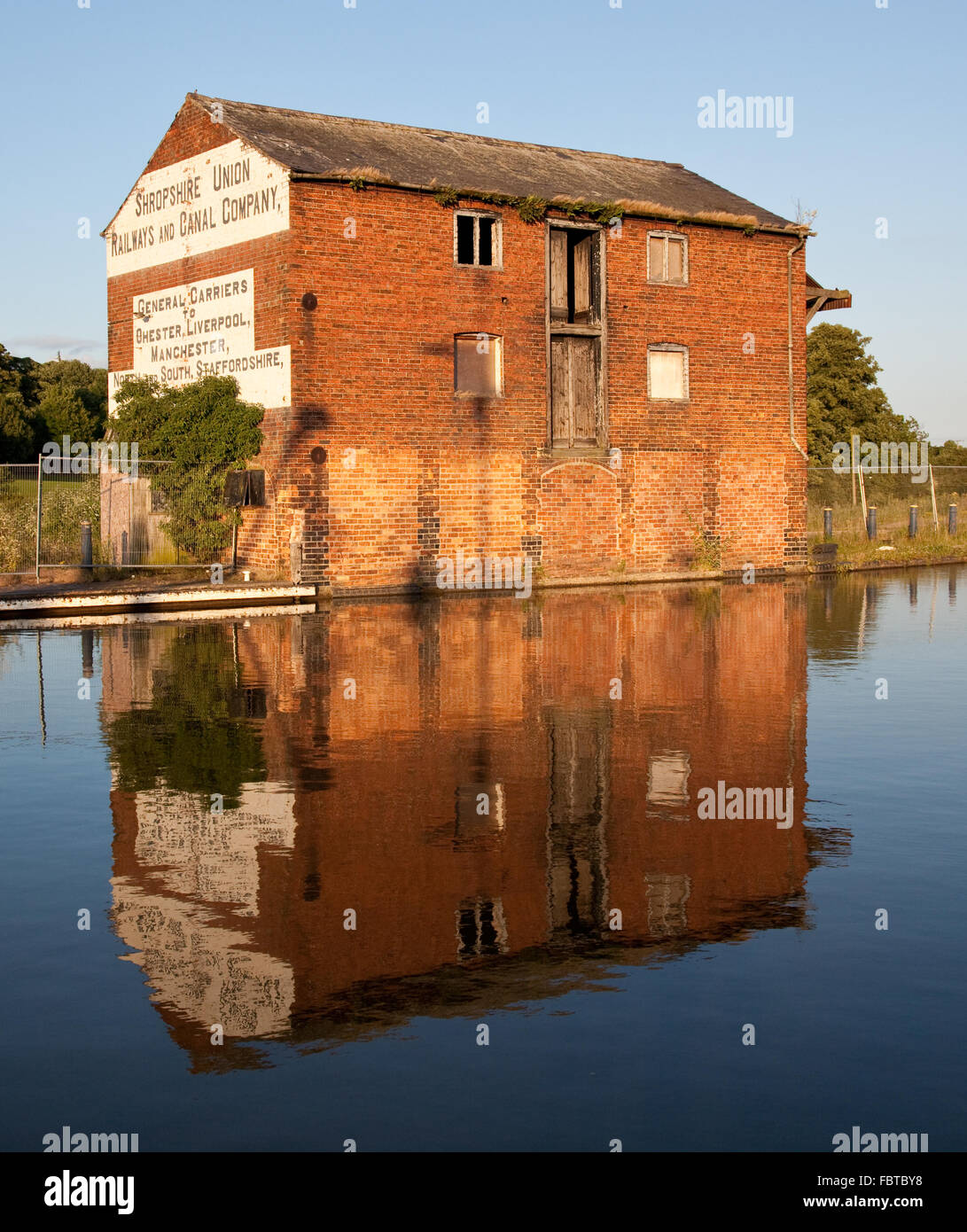 Ellesmere canal in Shropshire with old red brick warehouse Stock Photo