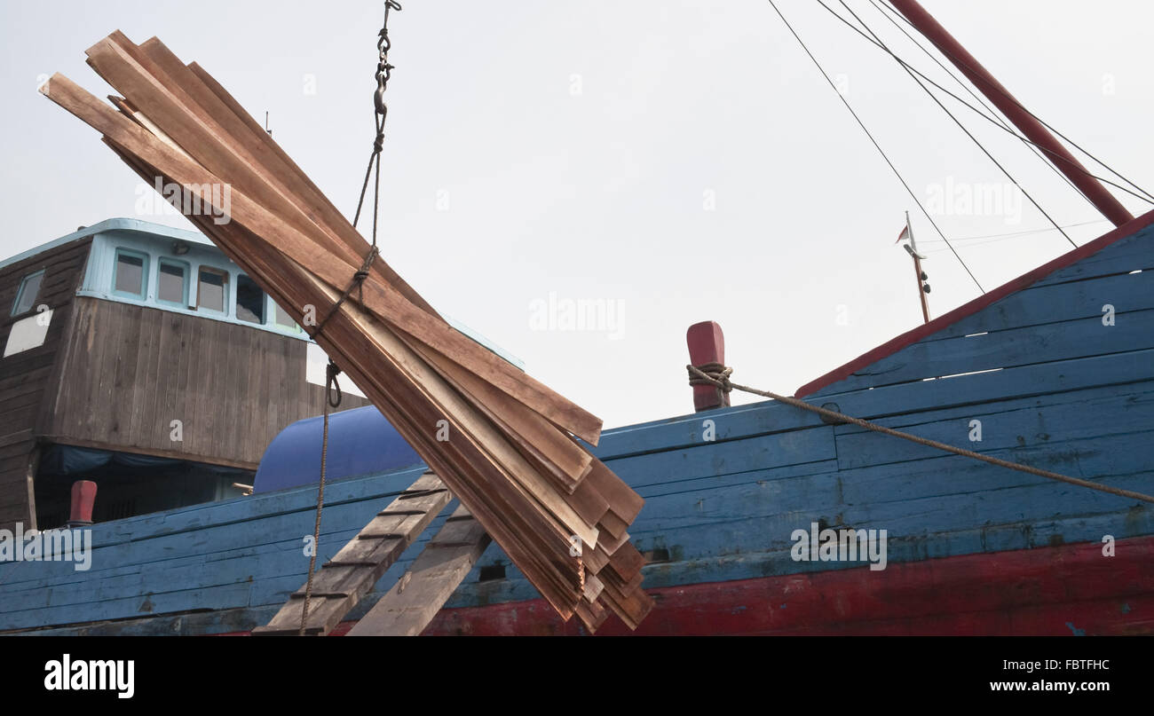 Wooden boards are loading in a cargo ship Stock Photo