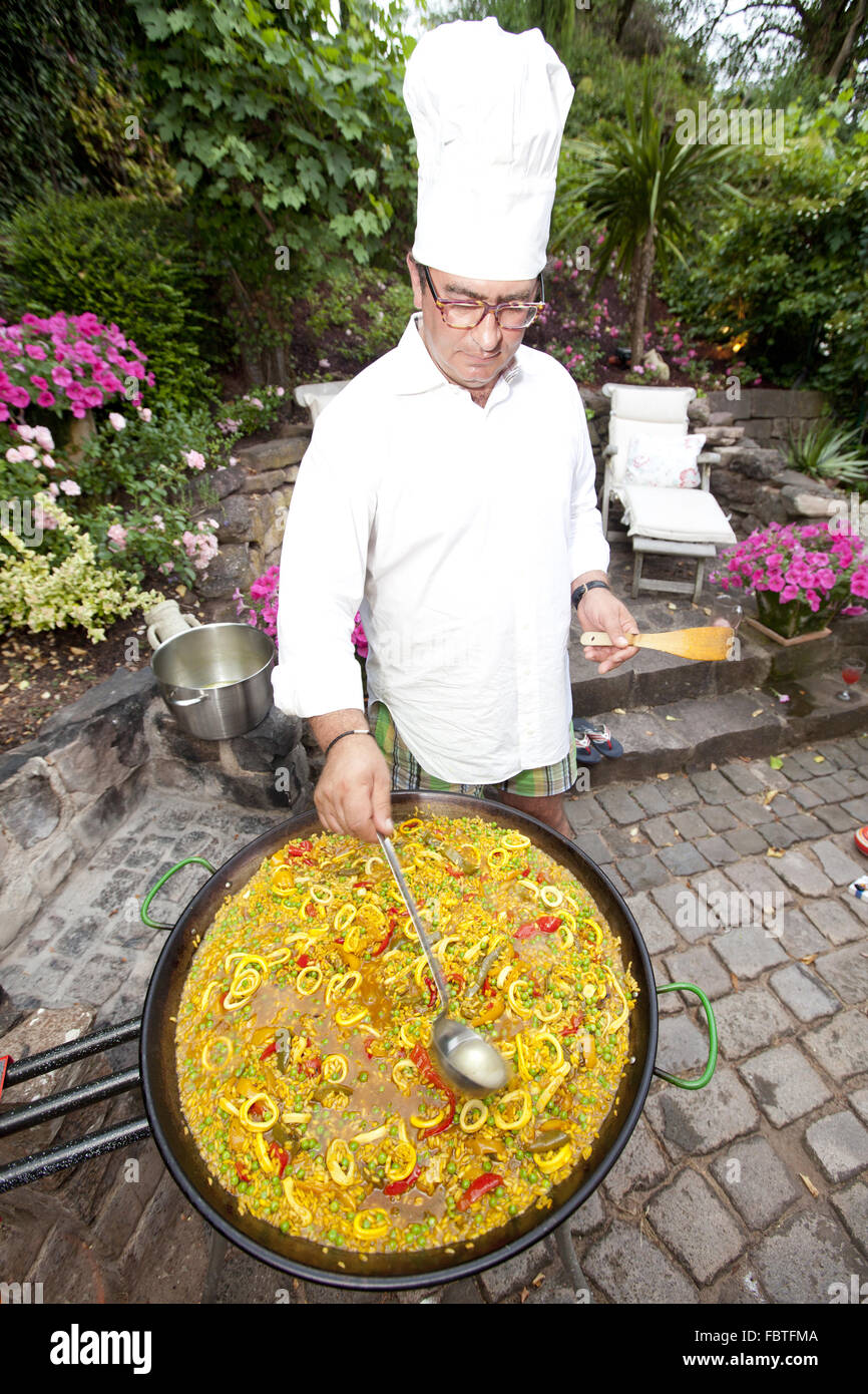 A cook prepares egg con paella Stock Photo