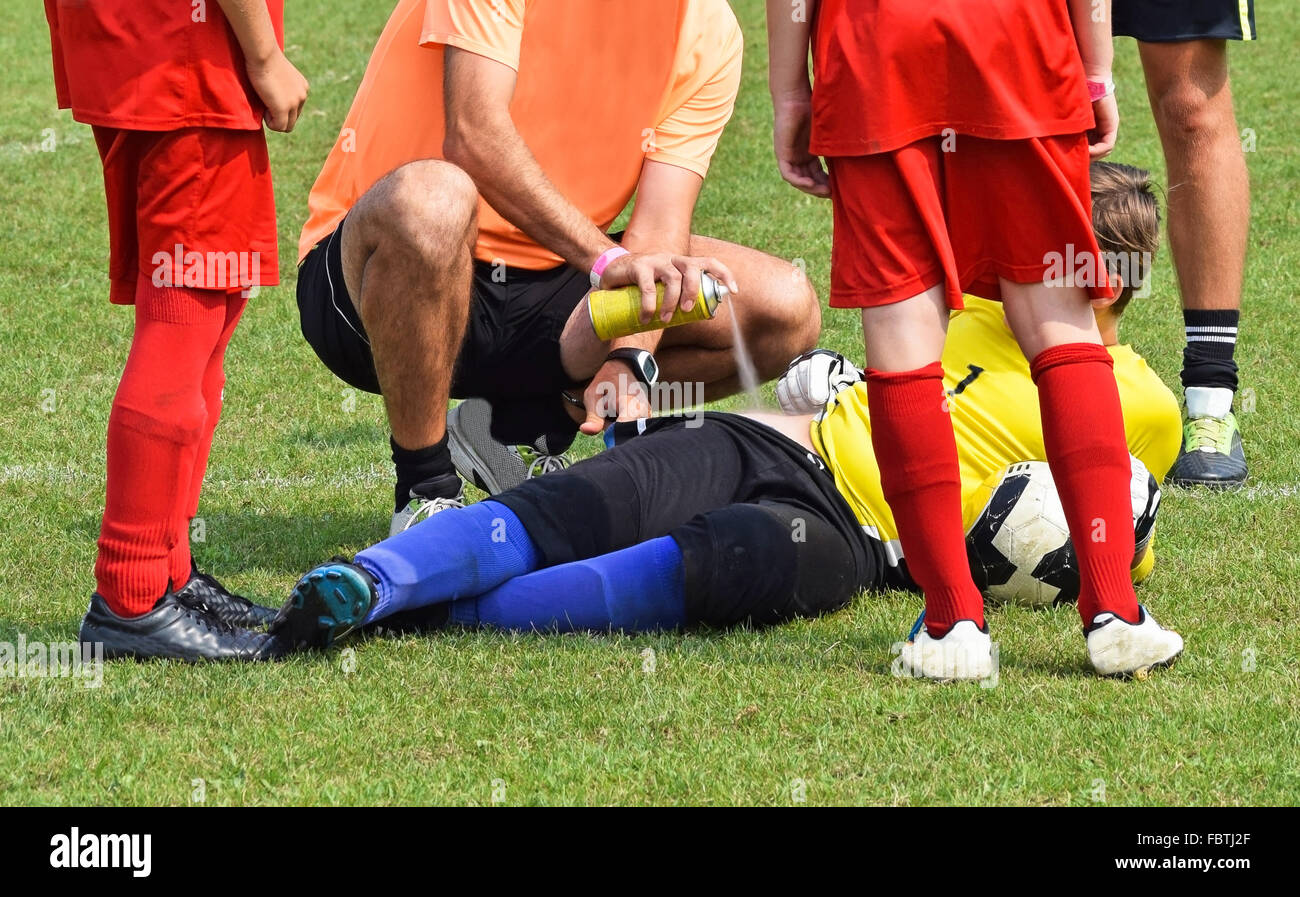 Injury on the soccer field, medic helps with a freezer spray Stock