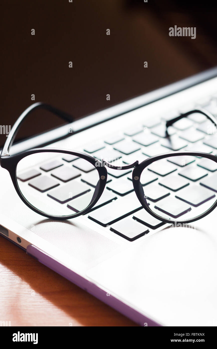 Workspace with eyeglasses on laptop, stock photo Stock Photo Alamy