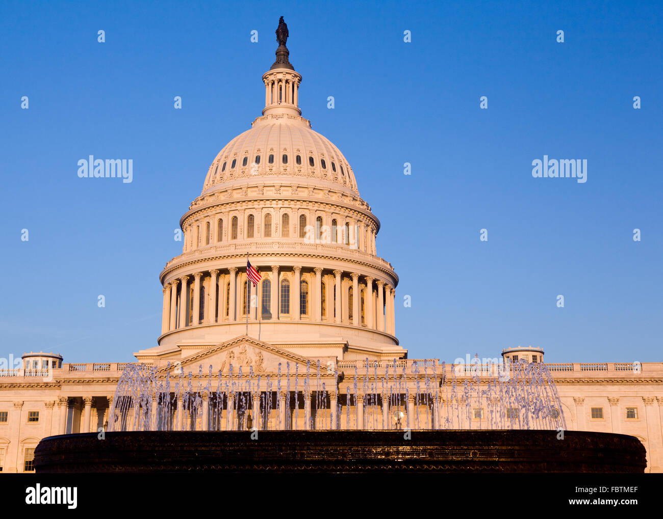 Rising sun illuminates the front of the Capitol building in DC Stock