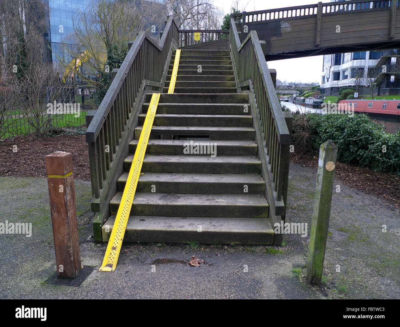 Cycle wheel ramp on canal bridge steps, Boston Manor Park footbridge over Grand Union Canal