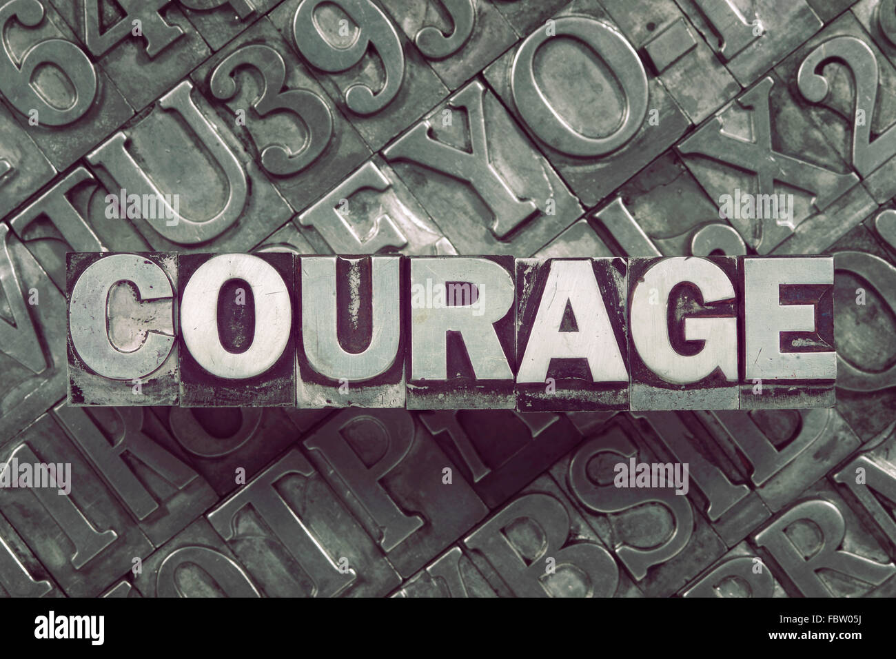 courage word concept made from metallic letterpress blocks on many letters background Stock Photo