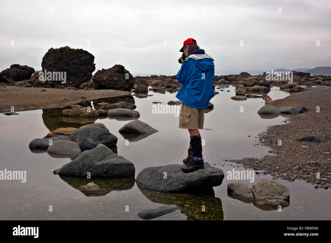 British Columbia Hiker Photographing Reflections Of Rocks In