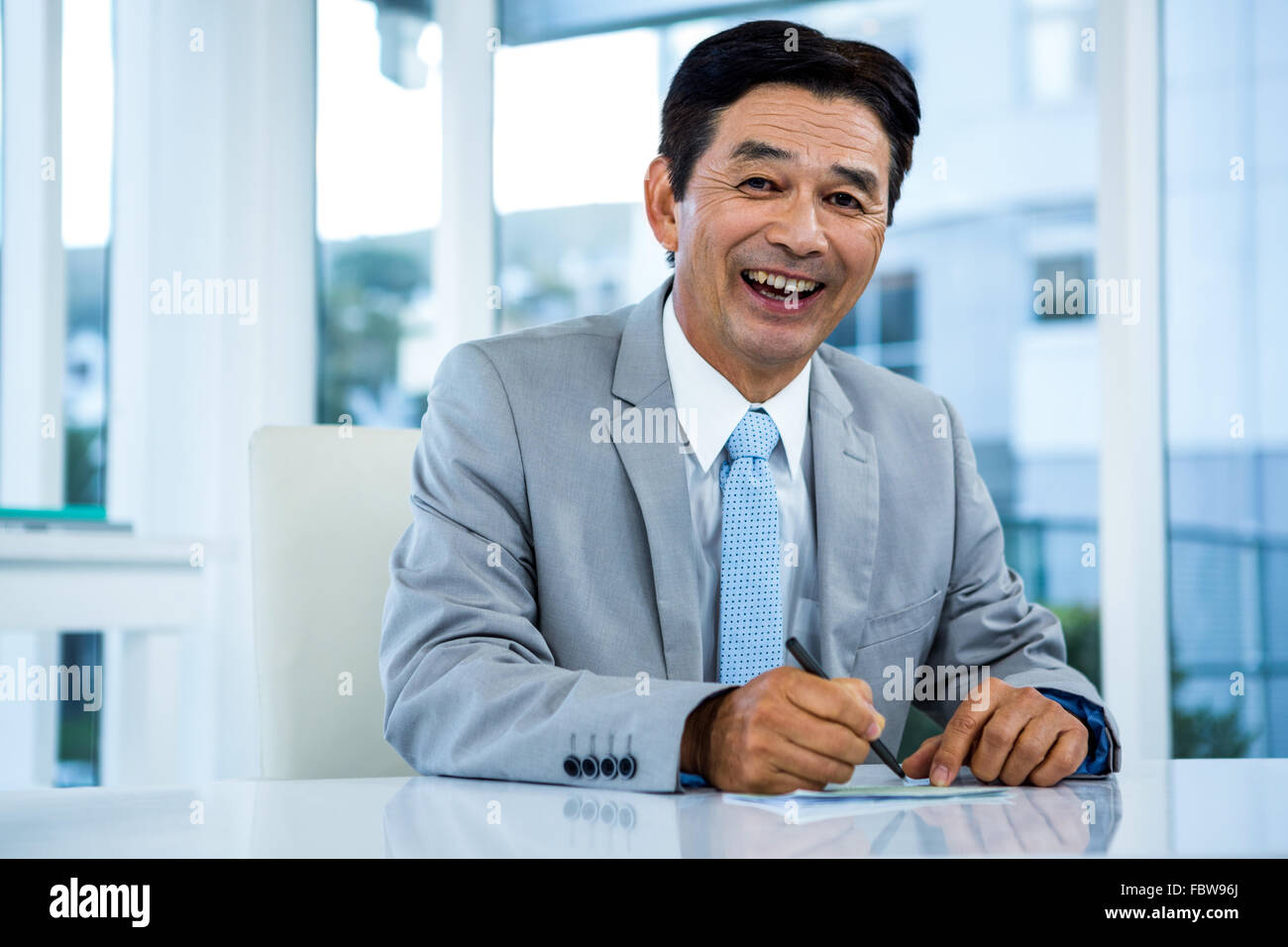 Happy businessman on his desk Stock Photo