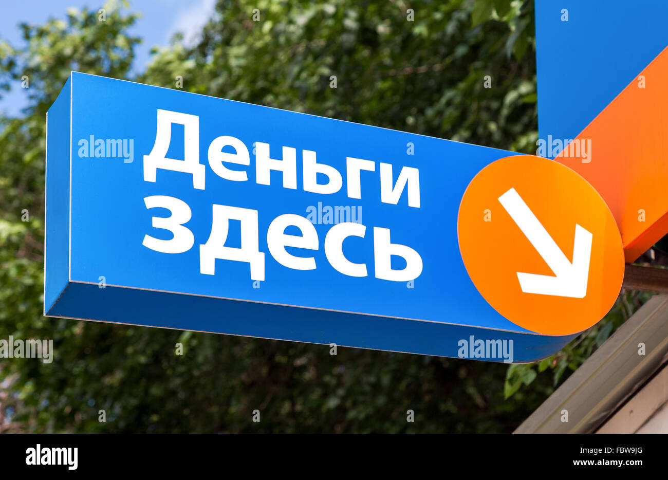 A sign on the facade of the microfinance organization. Text in russian: Money here Stock Photo