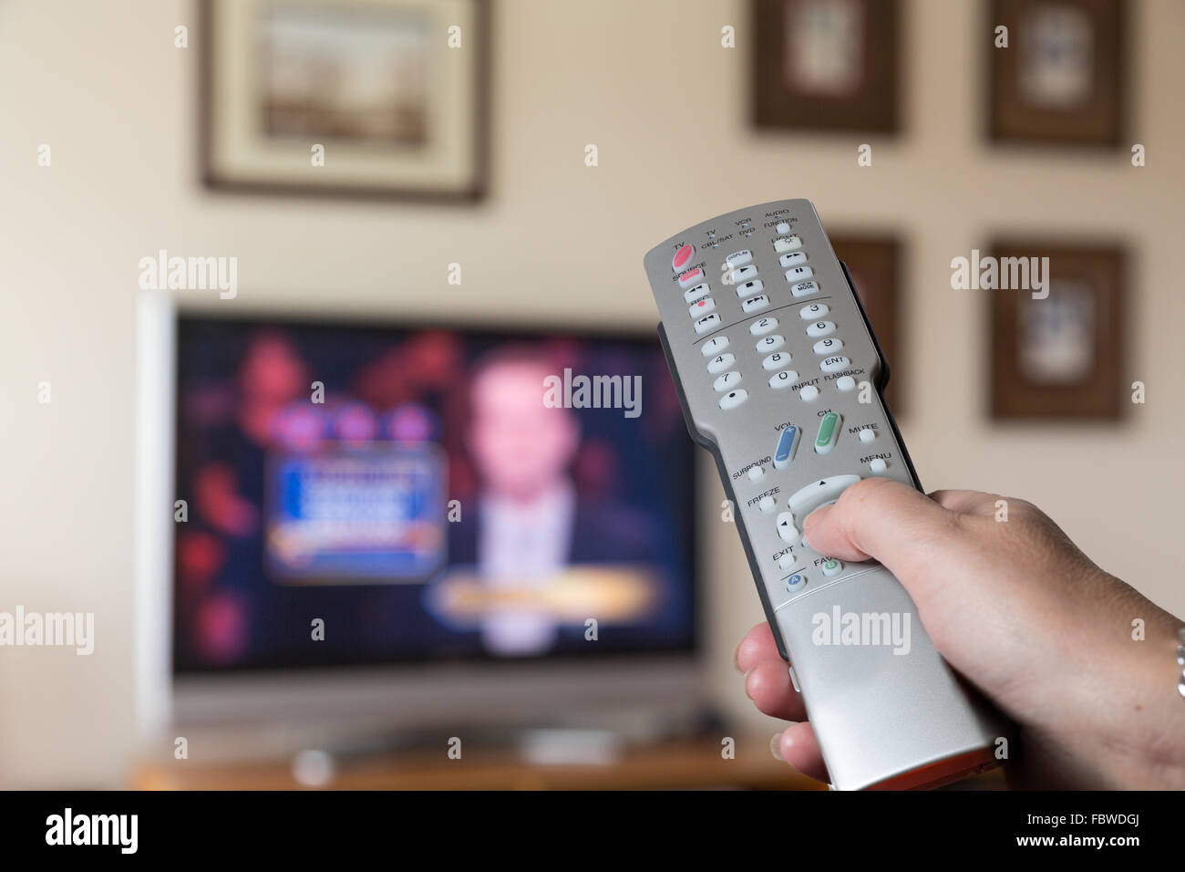 Silver remote control for TV with screen in back Stock Photo