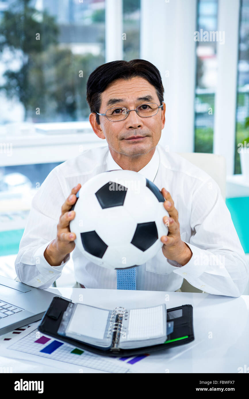 Asian businessman holding soccer ball Stock Photo - Alamy