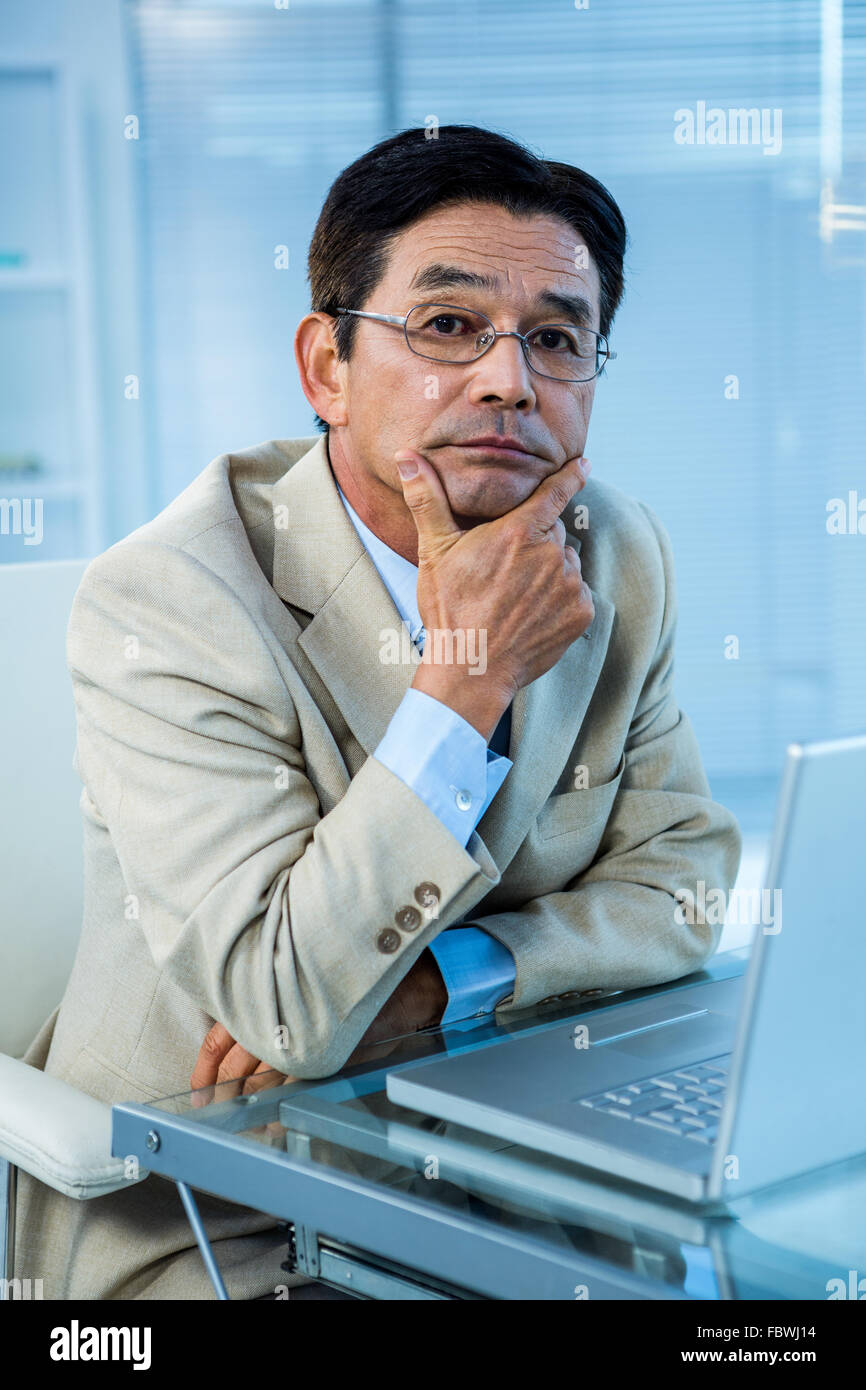 Thoughtful businessman looking at the camera Stock Photo - Alamy