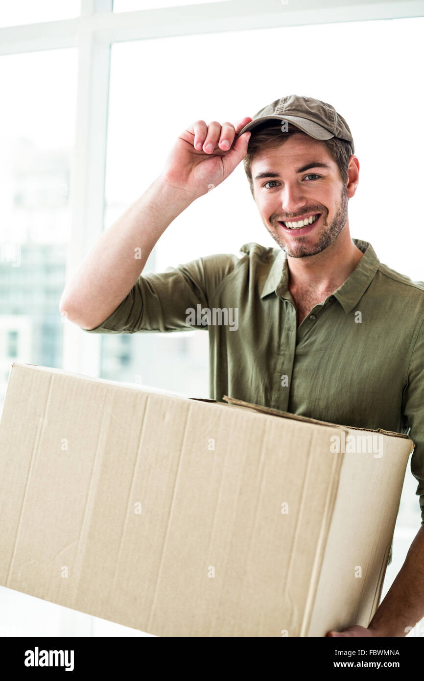 Smiling postman holding package Stock Photo