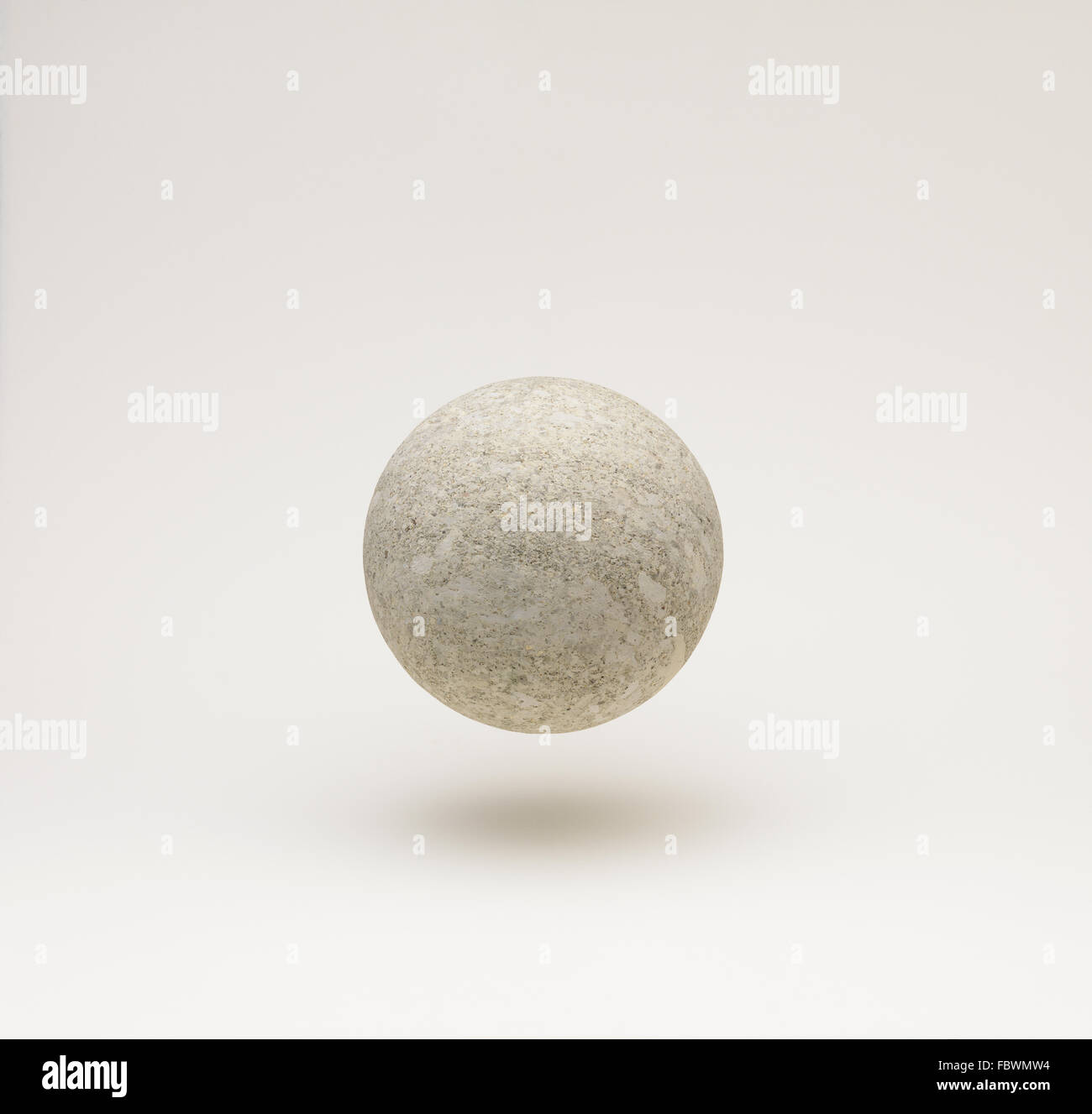 floating or falling stone ball or sphere on a neutral back ground Stock Photo