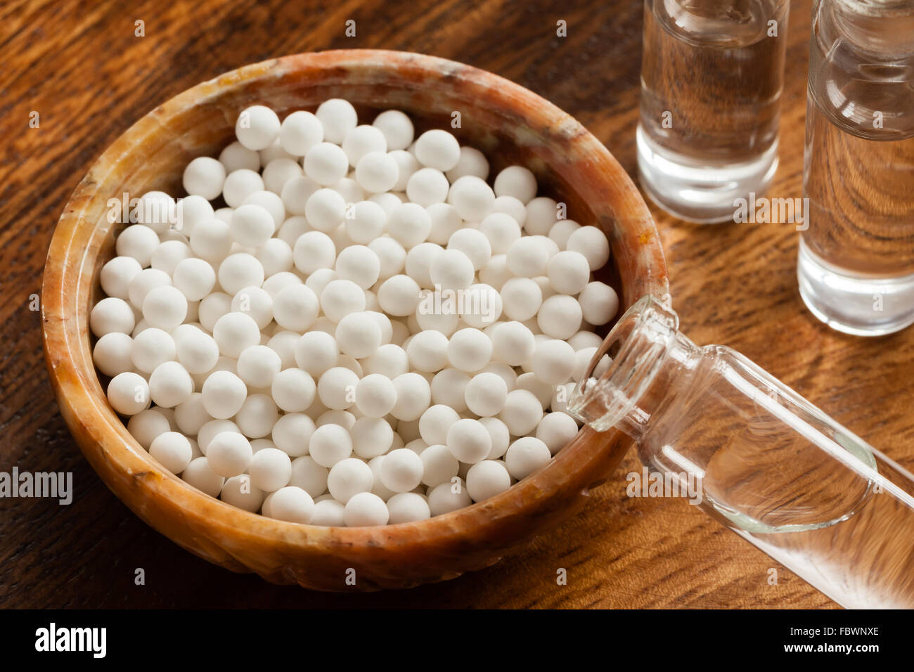 Macro image of homeopathic medicine consisting of the pills (made from an inert substance) and bottles of homeopathic liquid. Stock Photo