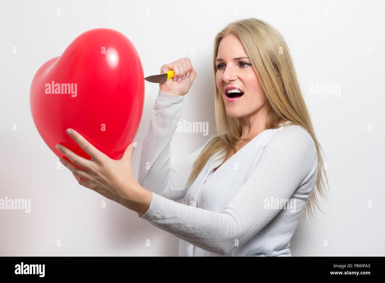 Woman destroying heart after breakup Stock Photo
