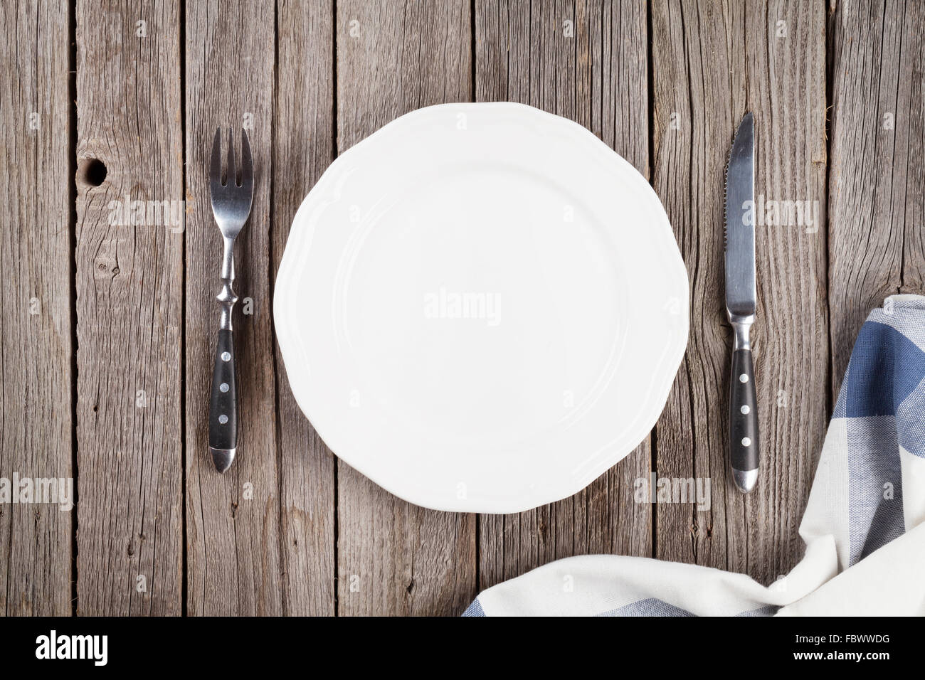 Empty plate and silverware on wooden table. Top view Stock Photo - Alamy