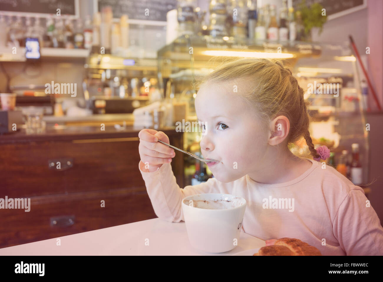 Beautiful young girl at the bar eating breakfast. Stock Photo