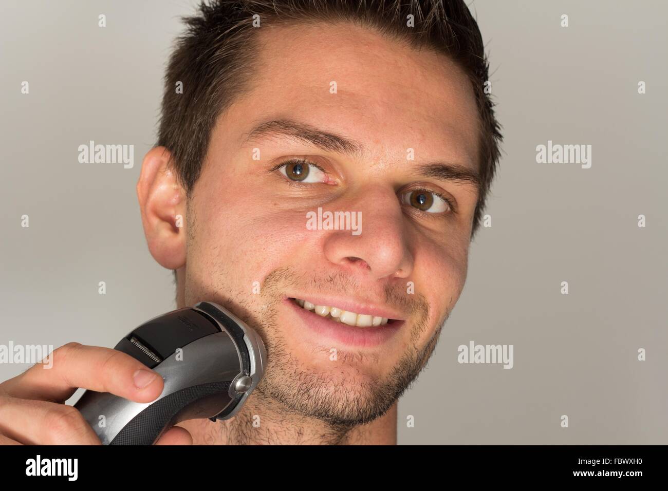 Man shaving face with electric razor Stock Photo Alamy