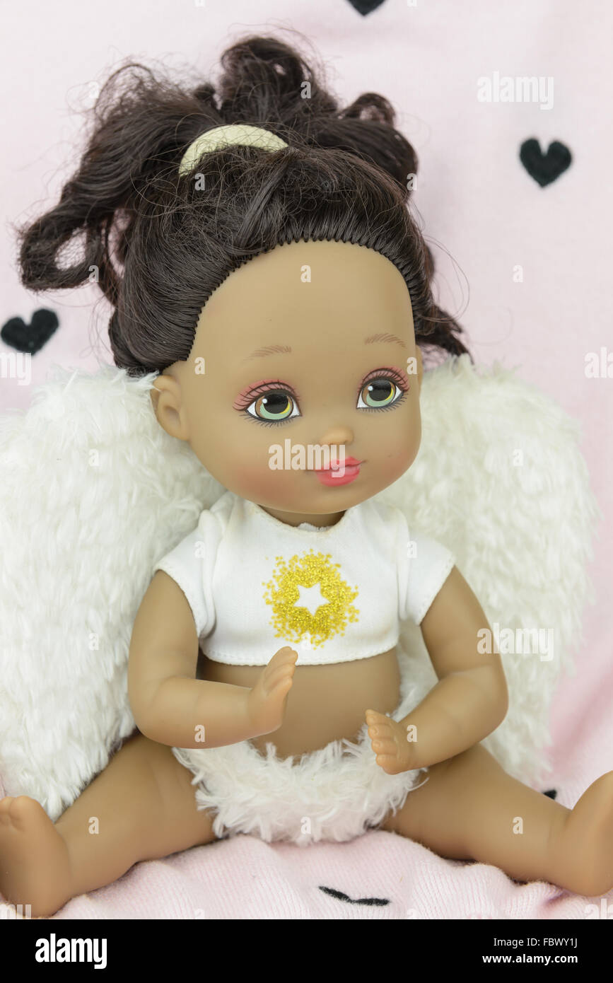 black, tan, skin tone doll in angel suit, white wings, girl Stock Photo