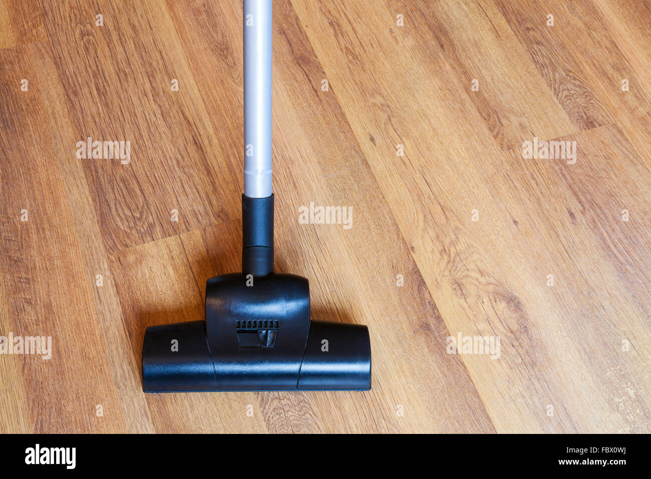 direct view of vacuuming of laminate floor by vacuum cleaner at home Stock Photo