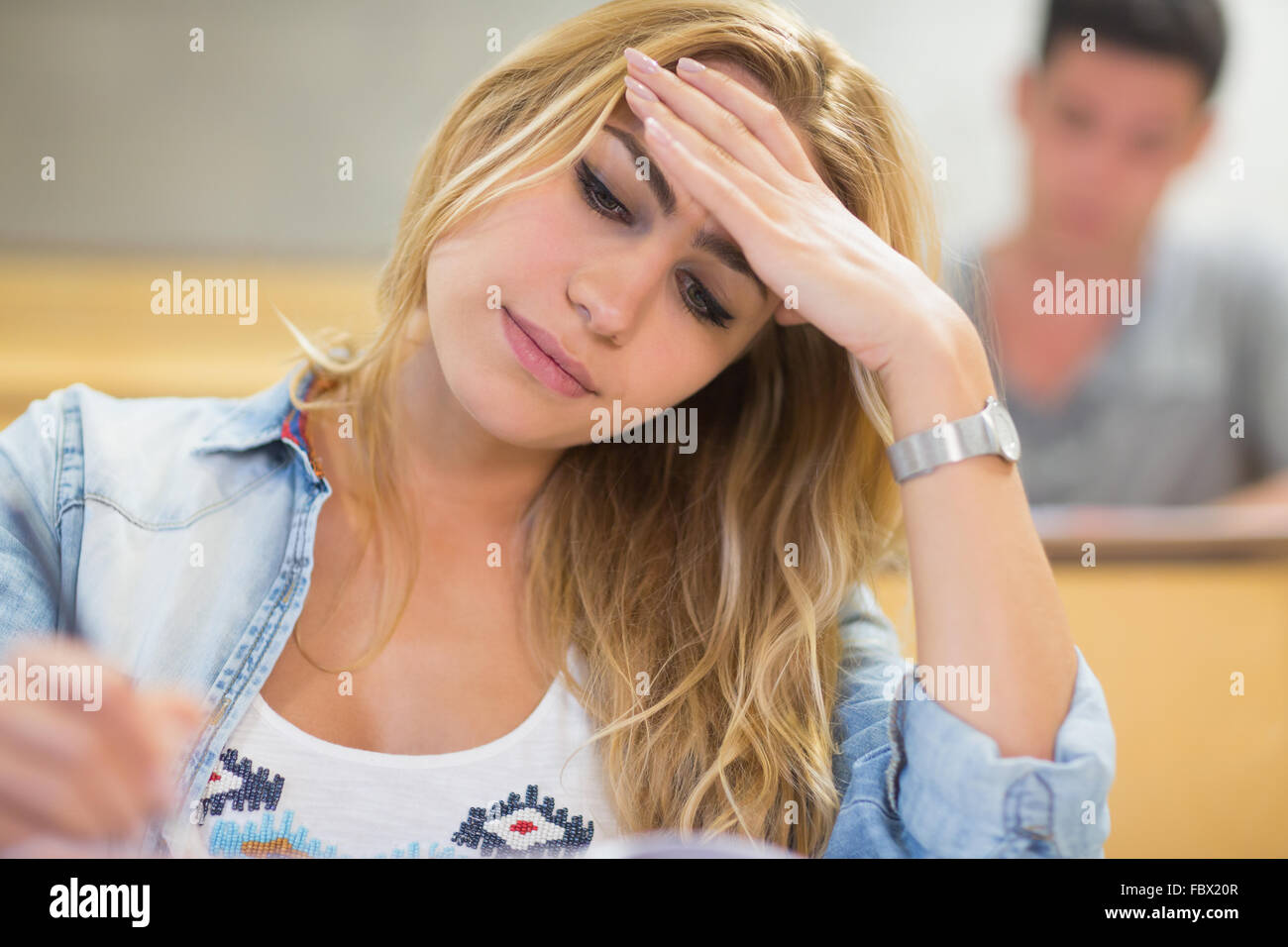 Attractive female student thinking during exam Stock Photo