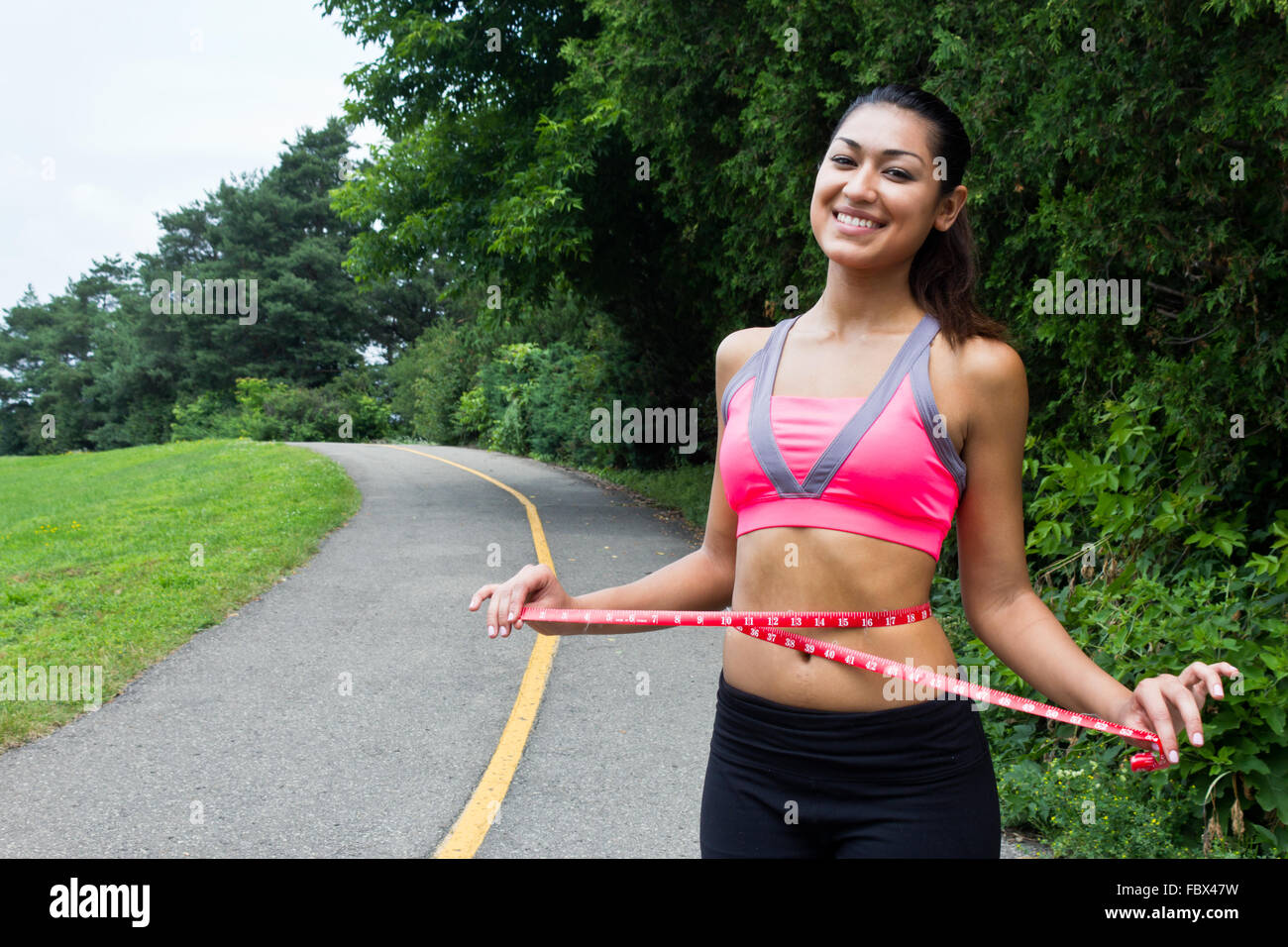 Young woman measures her waist Stock Photo