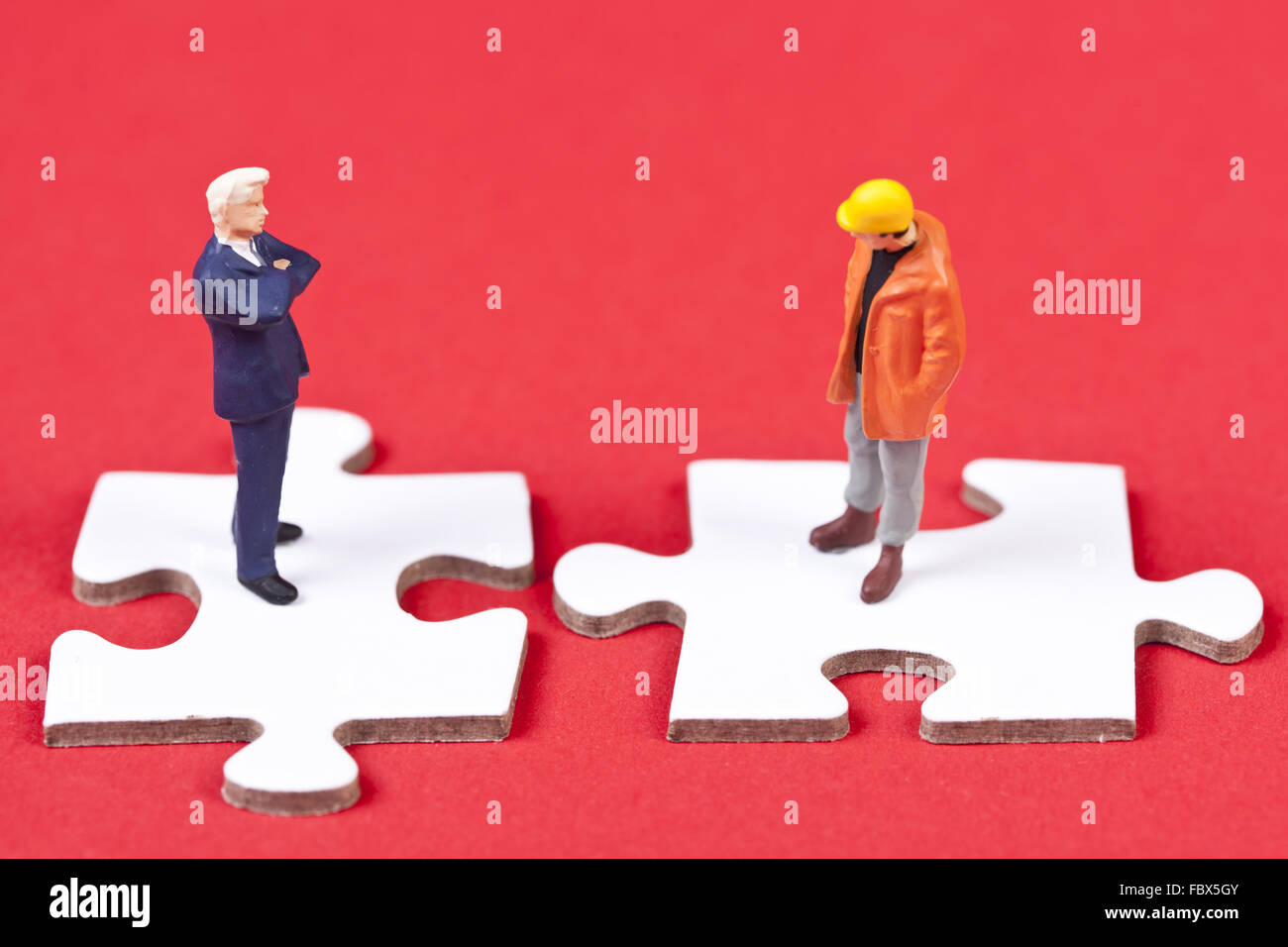 Two obvers figures on white puzzle pieces Stock Photo