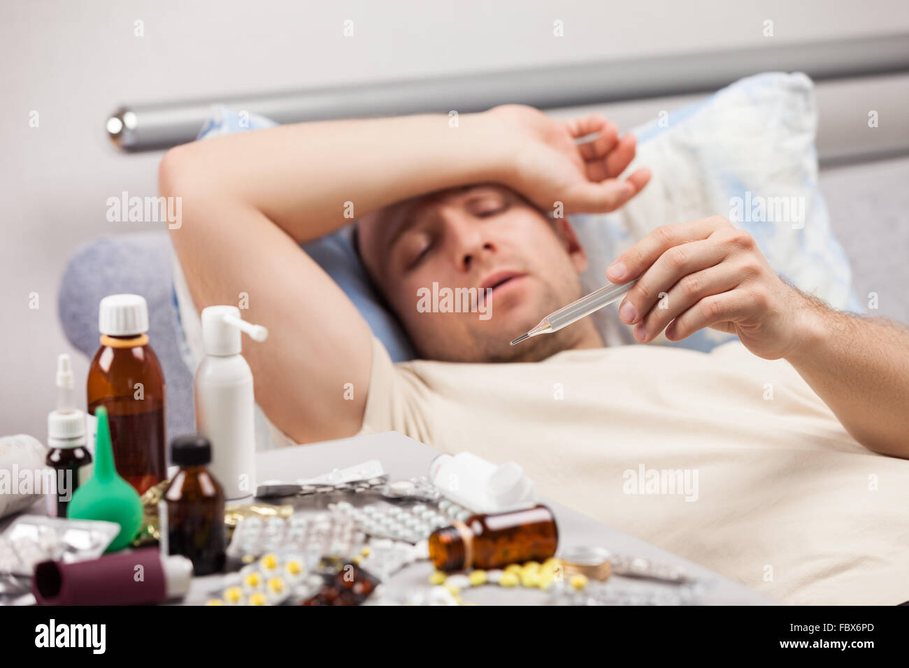 Unwell man patient lying down bed Stock Photo