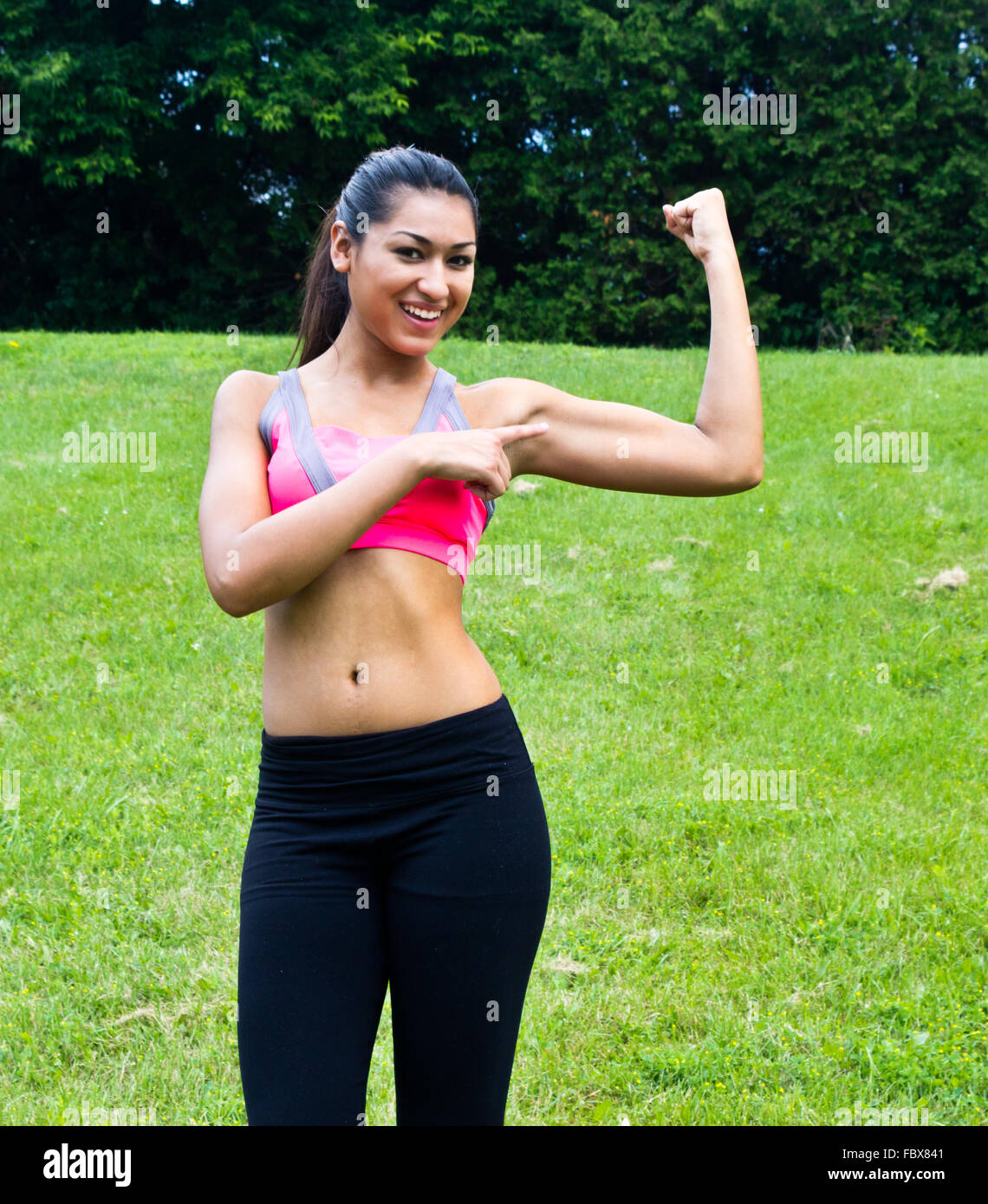 Young fit woman flexes her muscles Stock Photo