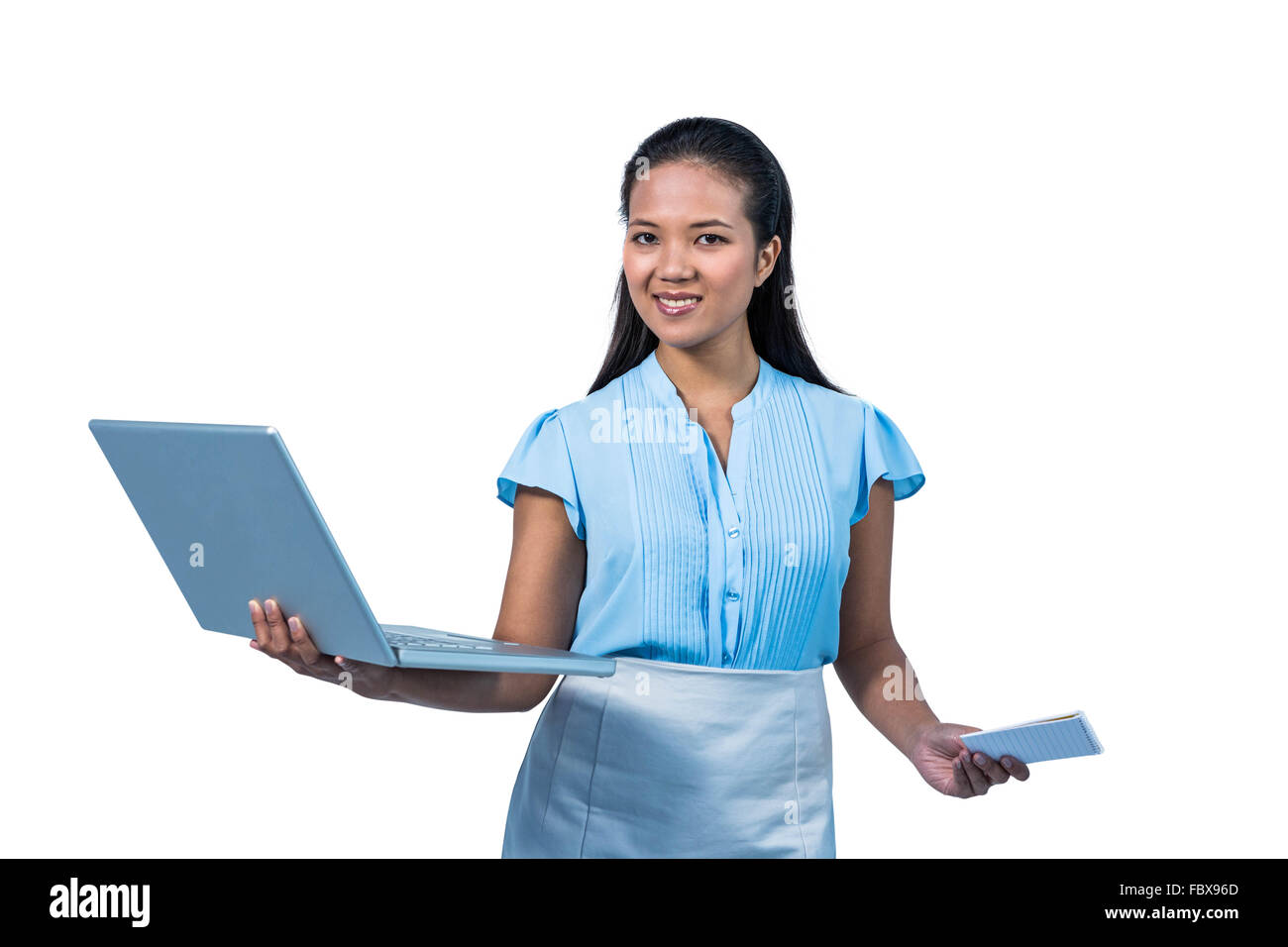 Smiling businesswoman holding smartphone and laptop Stock Photo